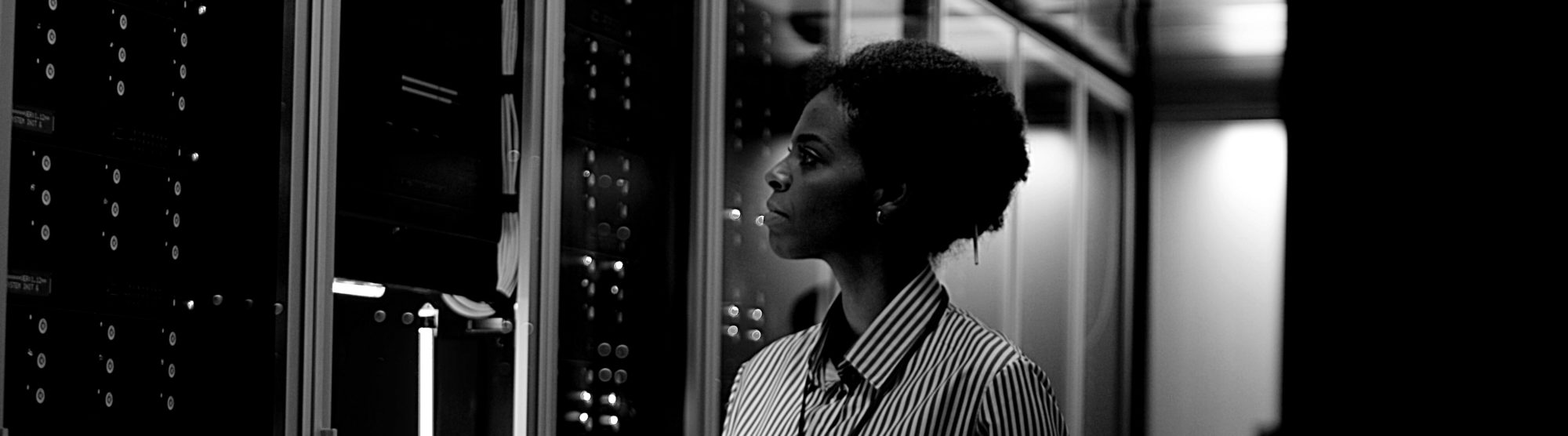 woman in business attire gazes at data center racks