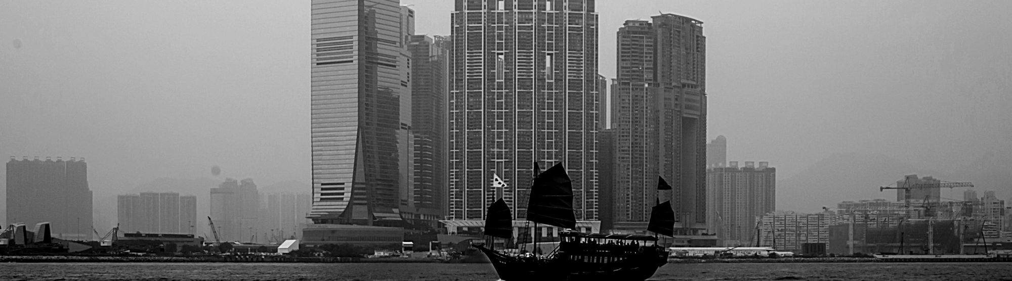 beautiful image of a Chinese city on the water, a traditional boat floats in front of the modern buildings. A metaphor for netTerrain's traditional quality amid ongoing modernizations